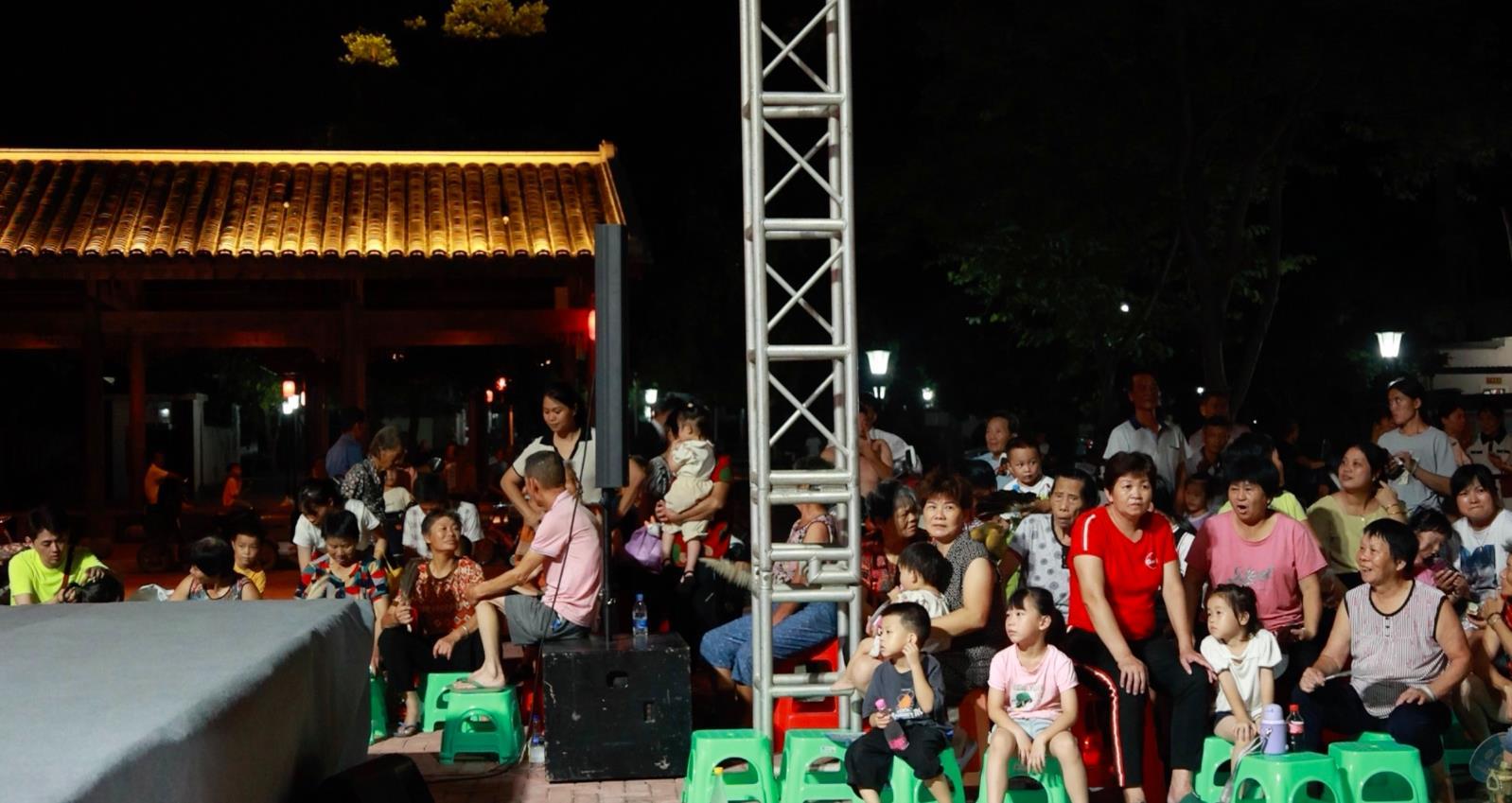 7月16日晚,村民们端坐成几排,享受着“文化大餐”。(王琳雅 摄)
